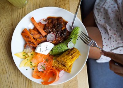 Colorful vegetarian meal with avocado, beans, and corn served on a wooden table. Ideal for healthy lifestyle visuals.